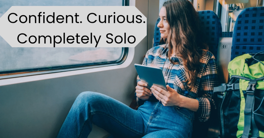 Solo female traveler sitting on a train, reading from a tablet, with backpack beside her – confident and independent journey