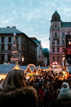 Crowded festive market in Budapest with Christmas decorations and lights.