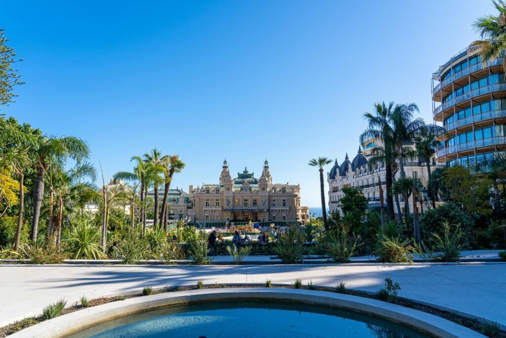 Stunning view of Hotel de Paris and Casino Monte Carlo with palm trees and blue sky.