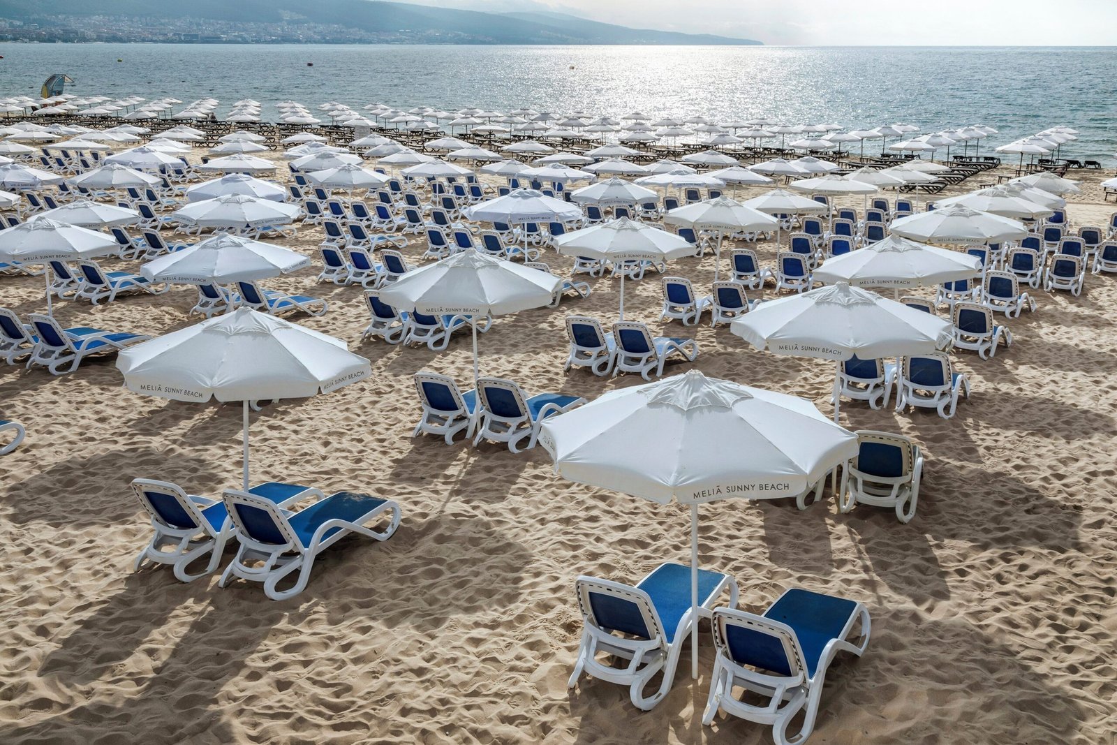 Empty beach with white umbrellas and loungers.