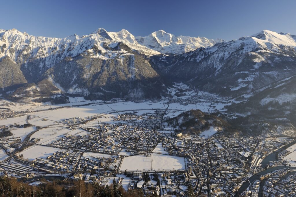 Snow-covered mountains above a village.